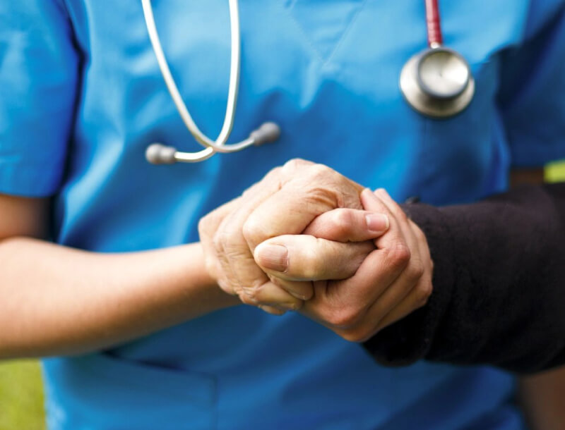 A nurse holding a person's hand